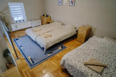 a bedroom with two beds and a blue rug at Košuta 21 Center Duplex Apartment, Brzeće in Brzeće