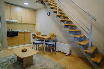a kitchen with a table and a staircase in a room at Košuta 21 Center Duplex Apartment, Brzeće in Brzeće