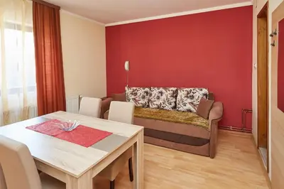 a living room with a table and a couch at Apartmani Stojadinović in Soko Banja