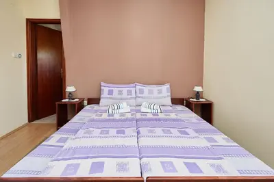 a large bed in a bedroom with two night stands at Apartmani Stojadinović in Soko Banja
