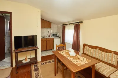 a living room with a table and a kitchen at Apartmani Stojadinović in Soko Banja