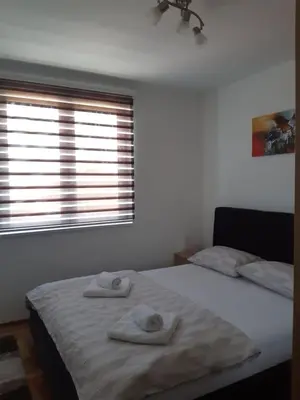 a bedroom with two towels on a bed with a window at Apartman Kala in Vrnjačka Banja