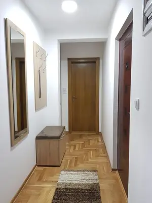 a hallway with a door and a wooden floor at Apartman Kala in Vrnjačka Banja