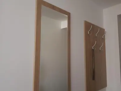 a mirror on a wall next to a door at Apartman Kala in Vrnjačka Banja