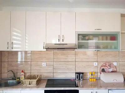a kitchen with white cabinets and a sink at Apartman Kala in Vrnjačka Banja