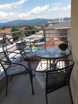 a table and chairs on a balcony with a view of a pool at Apartman Kala in Vrnjačka Banja