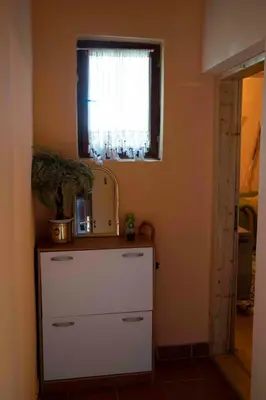 a kitchen with a white dresser and a window at Apartment Luka-Lena in Kopaonik