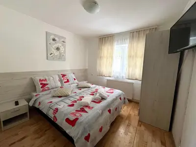 a bedroom with a bed with red hearts on it at Lili apartman u parku in Vrnjačka Banja