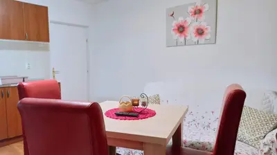 a dining room with a table and chairs and a table at Lili apartman u parku in Vrnjačka Banja