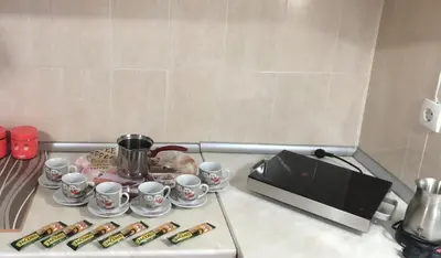 a stove top with cups and saucers next to a microwave at Lili apartman u parku in Vrnjačka Banja