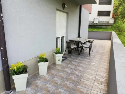 a patio with a table and chairs and plants at PremiumPlus Apartman in Vrnjačka Banja