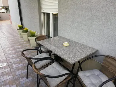 a table and chairs with a piece of cheese on it at PremiumPlus Apartman in Vrnjačka Banja