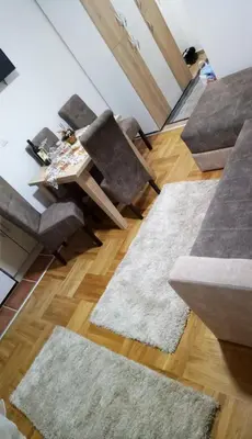 a living room with two chairs and a table at PremiumPlus Apartman in Vrnjačka Banja