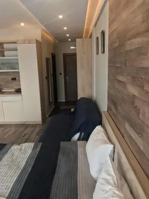 a bedroom with a bed and a stone wall at Studio Milmari ,Premier 18 in Kopaonik