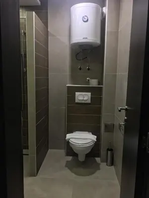 a bathroom with a toilet with a light above it at Studio Milmari ,Premier 18 in Kopaonik