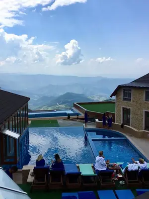 a group of people sitting around a swimming pool at Studio Milmari ,Premier 18 in Kopaonik
