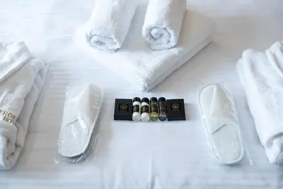 a white bed with towels and some bottles of pills at Apartmani Fashion -Milmari Resort in Kopaonik