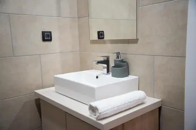 a bathroom with a white sink and a mirror at Apartmani Fashion -Milmari Resort in Kopaonik