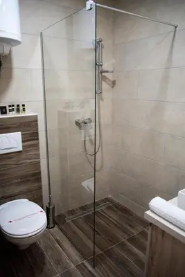 a shower stall in a bathroom with a toilet at Apartmani Fashion -Milmari Resort in Kopaonik