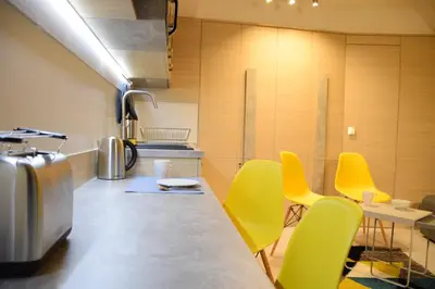 a kitchen with yellow chairs and a counter top at Family Lux Apartmani Angella Konaci in Kopaonik