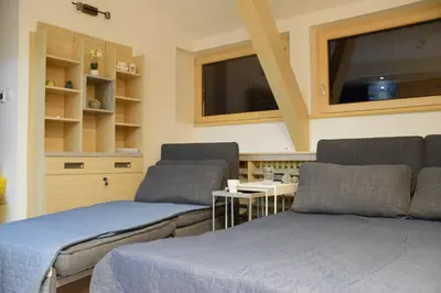 a living room with two beds and a table at Family Lux Apartmani Angella Konaci in Kopaonik