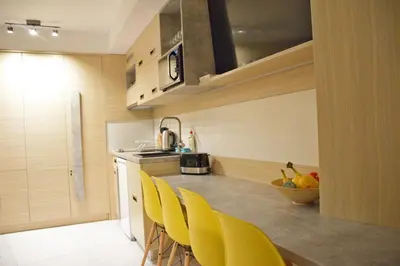 a kitchen with yellow chairs and a counter top at Family Lux Apartmani Angella Konaci in Kopaonik