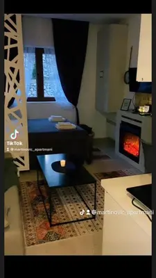 a living room with a bed and a fireplace at Apartman Suny N58 in Kopaonik