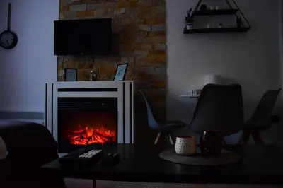 a living room with a fireplace and a table and chairs at Apartman Suny N58 in Kopaonik
