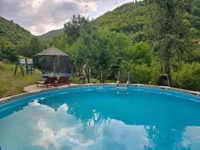 a swimming pool with a gazebo and a playground at Seosko domaćinstvo „GABAR” in Ćuštica