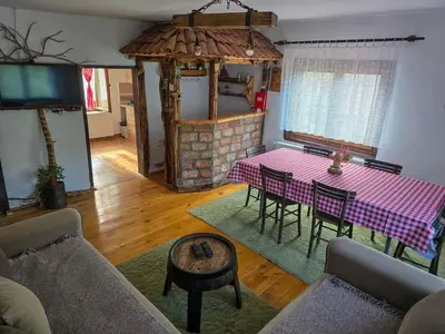 a living room with a table and a fireplace at Seosko domaćinstvo „GABAR” in Ćuštica