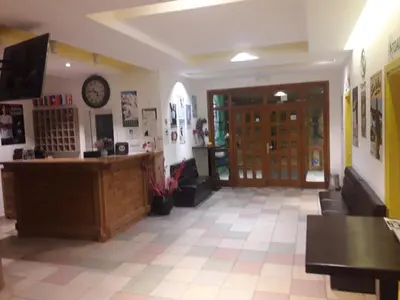 a lobby with a desk and a clock on the wall at Kopaonik Foka Spa Brzeće in Brzeće