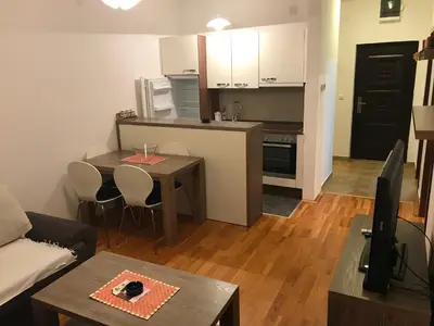 a living room with a table and a kitchen at Kopaonik Foka Spa Brzeće in Brzeće