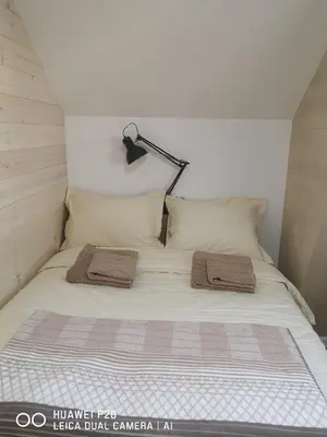 a bed with two towels on it in a room at KOPAONIK HOUSE in Kopaonik