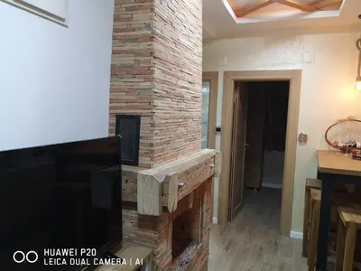 a brick fireplace in a living room with a tv at KOPAONIK HOUSE in Kopaonik