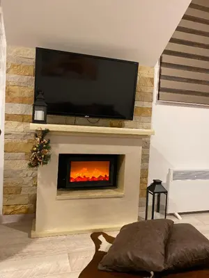 a living room with a fireplace with a flat screen tv at Studio Apartment Station Kopaonik,Milmari Resort in Kopaonik