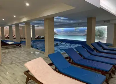 a swimming pool with blue chairs in a building at Studio Apartment Station Kopaonik,Milmari Resort in Kopaonik