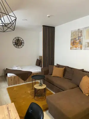 a living room with a couch and a table at Studio Apartment Station Kopaonik,Milmari Resort in Kopaonik