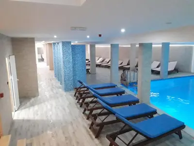 a group of lounge chairs and a swimming pool at APARTMAN BIKI in Kopaonik