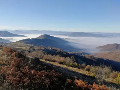 a view from the top of a mountain with clouds in the valley at APARTMAN BIKI in Kopaonik
