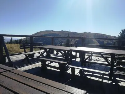 a group of picnic tables with a view of a mountain at APARTMAN BIKI in Kopaonik
