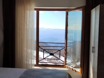 a bedroom with a window with a view at APARTMAN BIKI in Kopaonik