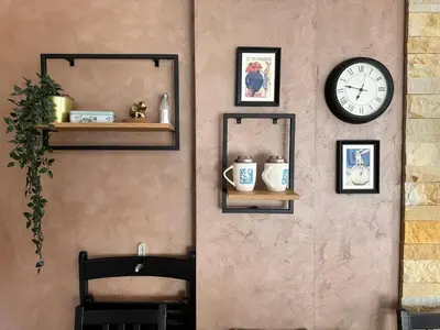 a wall with a clock and framed pictures and a chair at Nana S44 Milmari Spa&Wellness in Kopaonik