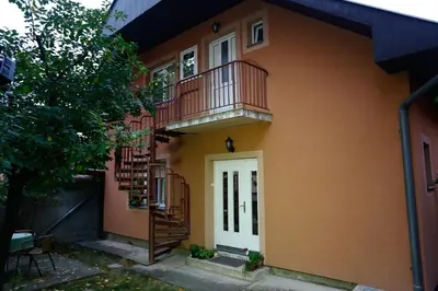a house with a balcony and a staircase at Apartman Carpe Diem 2 in Zaječar