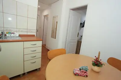 a kitchen with a wooden table and a table and a sink at Apartman Carpe Diem 2 in Zaječar