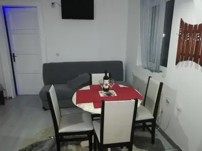 a dining room with a red table and chairs at Andrina Sweet Home in Niš
