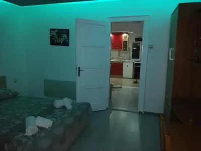 a bedroom with a bed and a door to a kitchen at Andrina Sweet Home in Niš