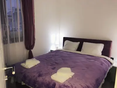 a bedroom with a purple bed with towels on it at Apartman “EMI” in Kopaonik