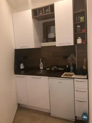 a kitchen with white cabinets and a sink at Apartman “EMI” in Kopaonik