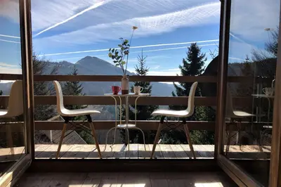 a table and chairs on a balcony with a view at Kostovac Boutique Homes - Loft in Kopaonik
