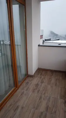 an empty room with wooden floors and glass doors at Milmari Premijer 30 Kopaonik in Kopaonik